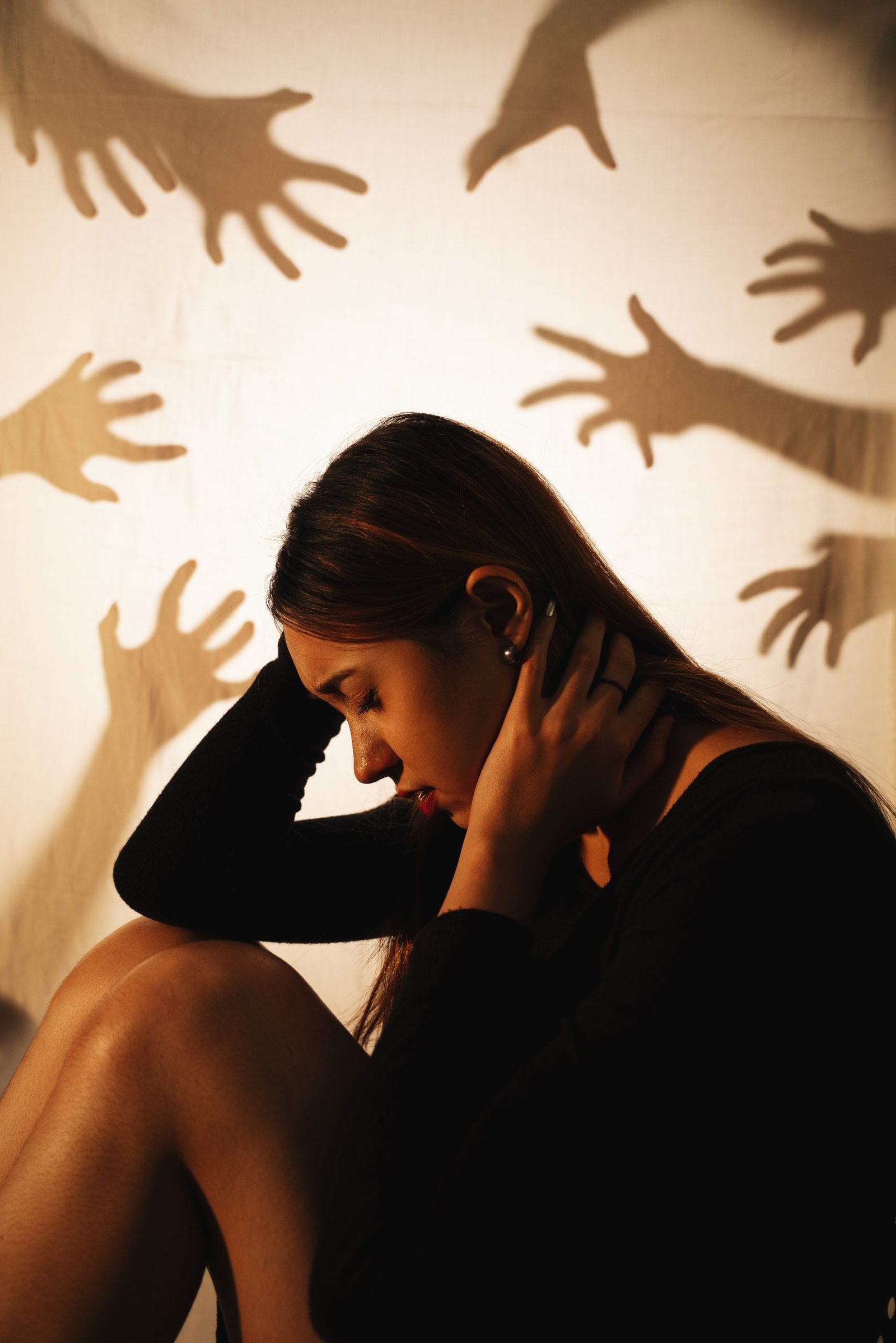 Woman sitting among the ghost hands. Beautiful mixed race woman sitting among the ghost hands.